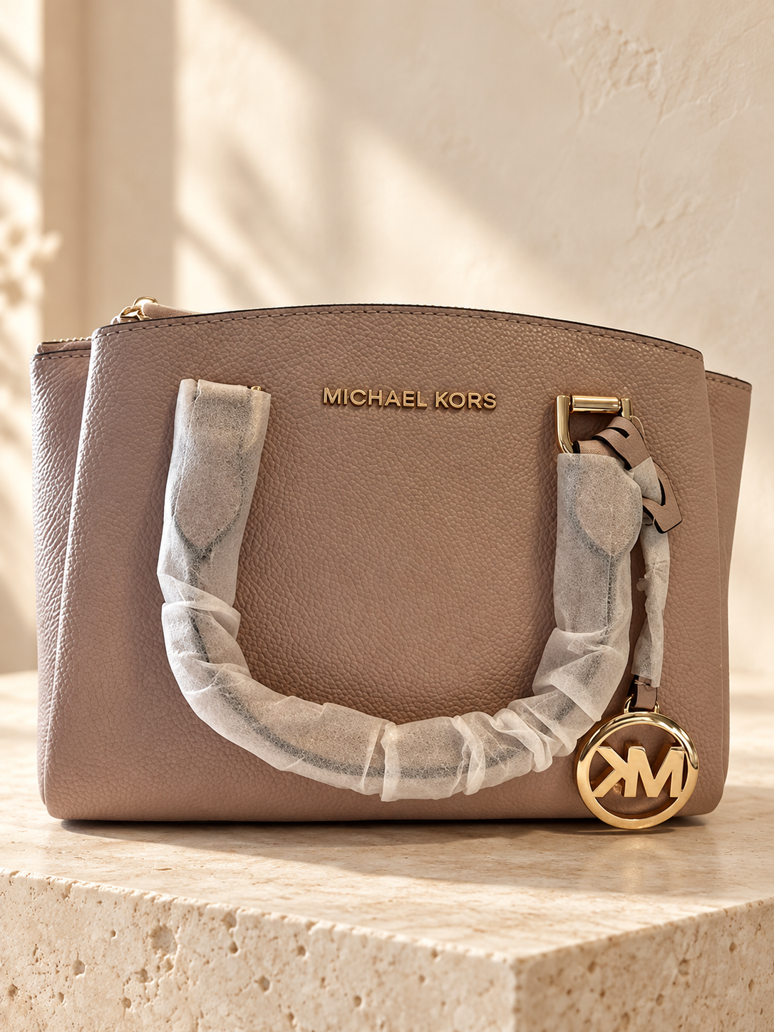 Michael Kors Maxine Soft Pink bag against a warm cream studio backdrop